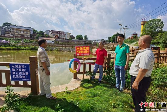那阳镇人大主席乐兴泉（左二)检查黄村防溺水工作。横州市人大供图