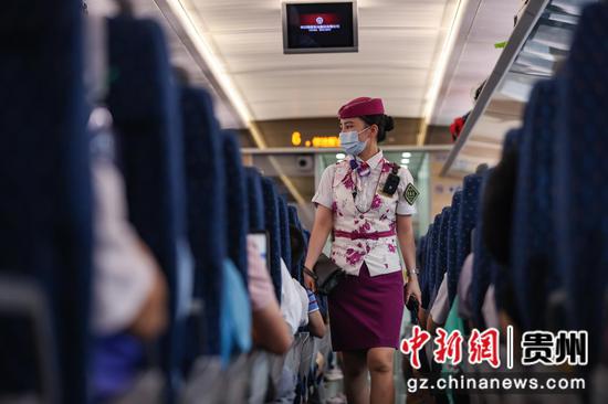 7月26日，贵阳北开往成都东的G5392次列车上，列车安全员在检查行李。 瞿宏伦 摄