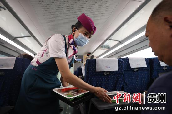 7月26日，贵阳北开往成都东的G5392次列车上，乘务员在为旅客送餐。 瞿宏伦 摄