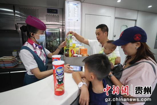 7月26日，贵阳北开往成都东的G5392次列车上，乘务员在为旅客服务。 瞿宏伦 摄