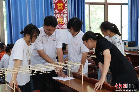宣讲团成员指导同学们搭建桥梁模型广西大学供图