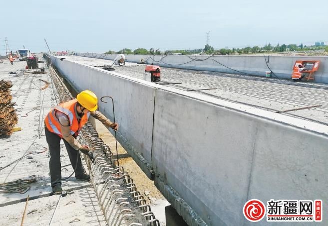 　　7月30日，工人在乌鲁木齐绕城高速（西线）工程五一连接线大桥进行防撞护栏施工。 （全媒体记者史传芝 通讯员倪跃摄）

