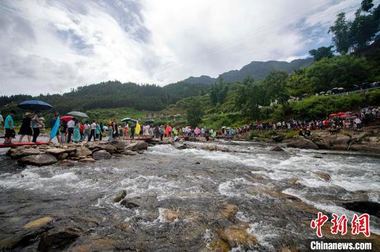 在贵州省从江县刚边壮族乡刚边村，人们前往参加跳水节活动。吴德军 摄