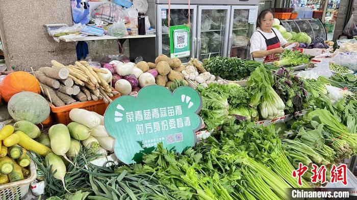 位于蔬菜攤位的反詐宣傳標(biāo)語(yǔ)。辛雪 攝