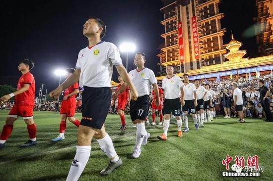 6月10日晚，小瑞村足球队（红衣）与车江三村足球队入场。中新社记者 瞿宏伦 摄