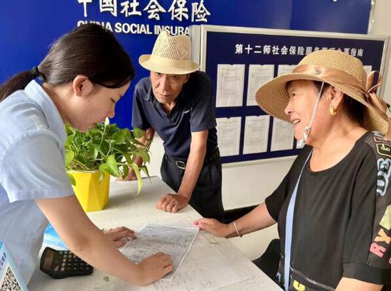 十二师社保中心工作人员为辖区退休群众讲解养老金政策。刘倩 摄