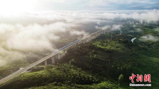 图为航拍首发列车通过银坡河双线特大桥。马奎宏 摄