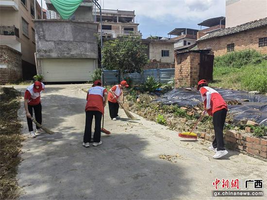 志愿者清扫乡村街道。刘芳  摄