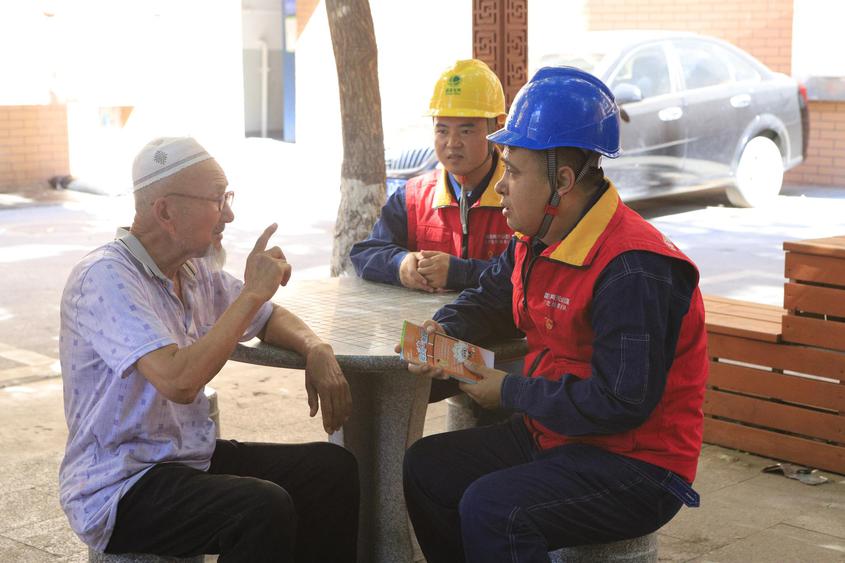 8月4日，“雪莲·光明驿站”工作人员在大巴扎社区为老人宣传安全用电注意事项。勾佳祺 摄