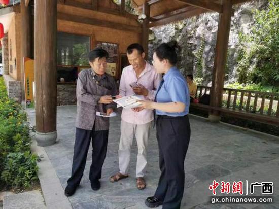 检察干警向群众宣传如何防范电信网络诈骗。黄丽培 摄