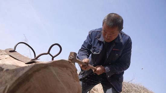 丁学生会根据之前测量好的马背宽度、厚度与马的高度,比照尺寸,一点点通过反复敲打调整马鞍骨架的形状 李蓉摄 丁学生会根据之前测量好的马背宽度、厚度与马的高度,比照尺寸,一点点通过反复敲打调整马鞍骨架的形状 李蓉摄