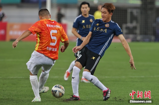 图为香港明星足球队队员马国明（蓝衣）在比赛中。