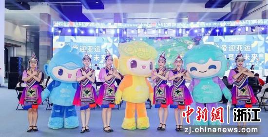 身穿畲族服饰的姑娘与杭州亚运会吉祥物合影。景宁县委宣传部供图