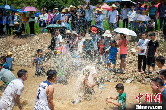 8月19日在贵州省从江县斗里镇马安村，人们在闹鱼活动中戏水抓鱼。吴德军 摄