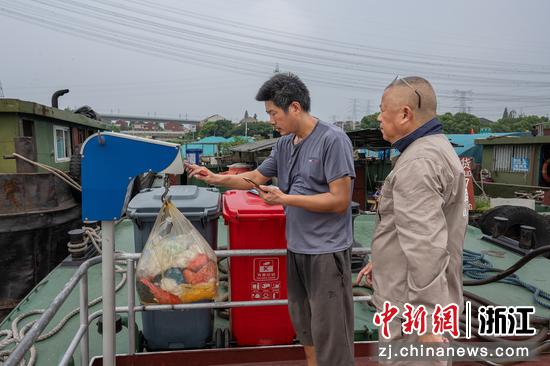 工作人员在清污船上接收生活垃圾。 中新社发 周宇 摄
