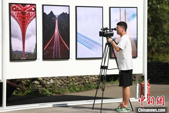 一位媒体在拍摄展出的桥梁摄影作品。瞿宏伦 摄