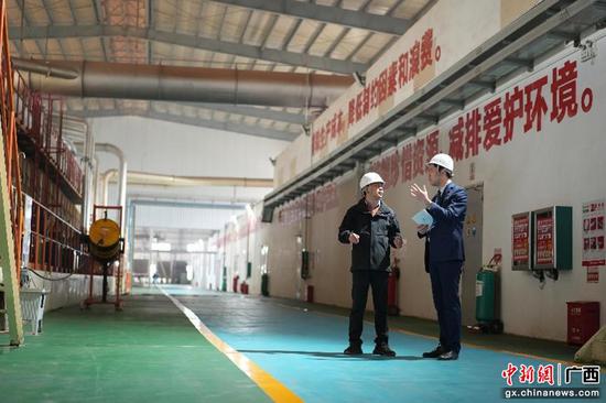 广西北部湾银行客户经理在环保新材料企业车间调研。