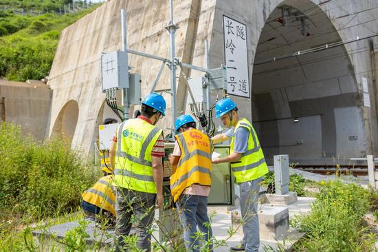 广西移动通信工程师检查隧道旁网络通信设备。