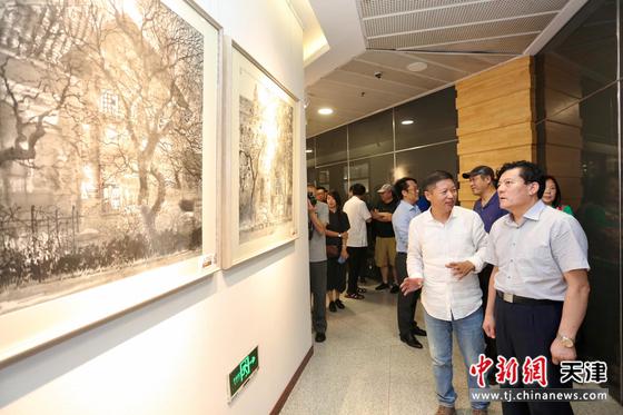 图为画家魏瑞江（右二）在展览现场介绍作品。刘俊苍 摄
