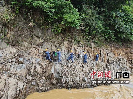 8月26日，因连续降雨，造成道路中断，南方电网广西电网公司抢修作业人员徒步运送物资前往抢修现场。 罗晓瑞  摄