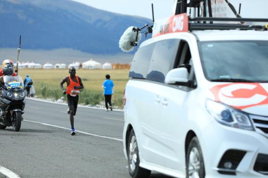 获得马拉松比赛第一名的肯尼亚选手途经保电服务点。徐兢兢 摄