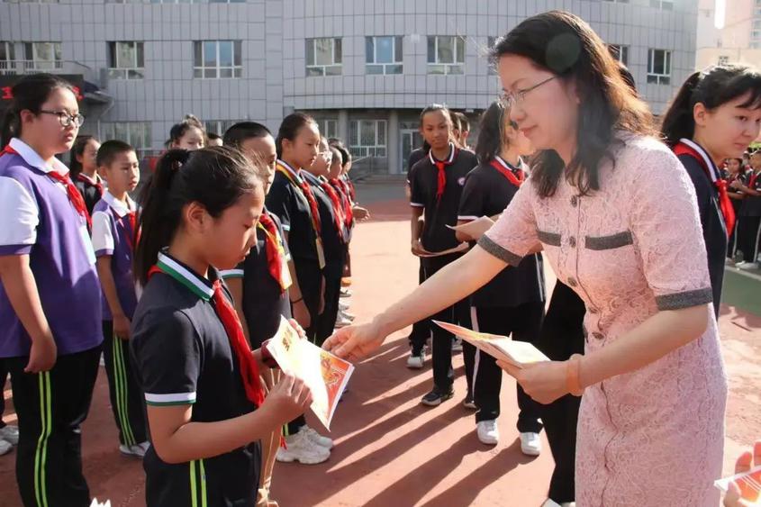 校领导为三好学生颁发奖状，鼓励同学们新学期再接再厉。