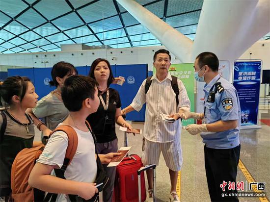 图为民警对中国(南宁)往返文莱(斯里巴加湾)航班旅客的出入境证件进行查验。韦州摄影 图为民警对中国(南宁)往返文莱(斯里巴加湾)航班旅客的出入境证件进行查验。韦州摄影