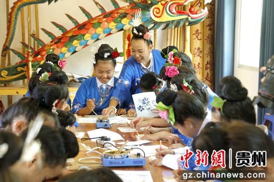 2023年8月30日贵州施秉县双井镇苗族独木龙舟展示馆龙梅技师指导学生绘画。