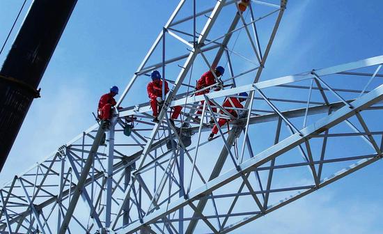 9月3日，巴州—铁干里克—若羌750千伏输电线路工程作业人员在铁塔上安装塔材、紧固螺栓。马元 摄