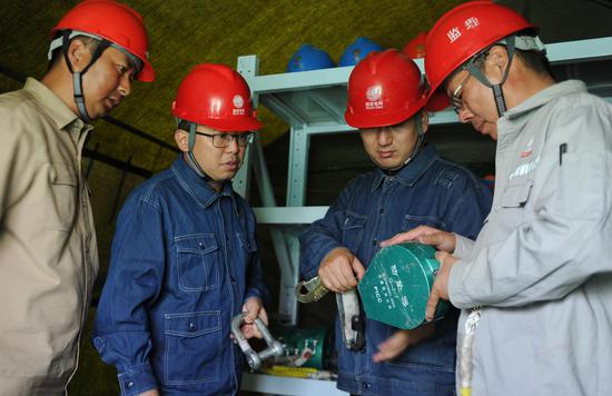 9月3日，巴州—铁干里克—若羌750千伏输电线路工程建设现场，业主项目经理李俊（左二）在检查工器具。马元 摄