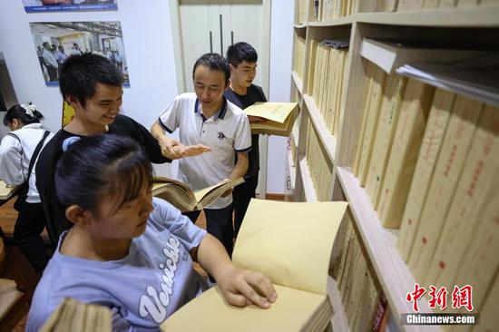9月7日，贵州省惠水县，罗强在协助学生拿取盲文版医学书籍。