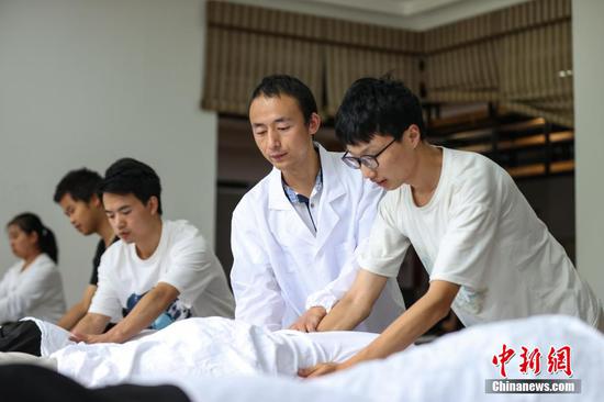 9月7日，贵州省惠水县，罗强（中）在进行推拿手法实操课程。
