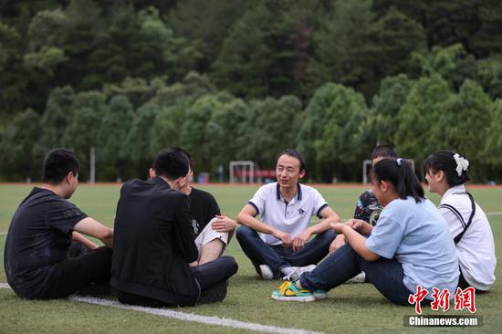9月7日，贵州省惠水县，罗强在足球场和学生们交流谈心。