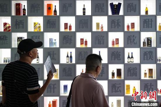 酒博会现场酒企设置的酒瓶展示墙吸引参观者。中新网记者 瞿宏伦 摄
