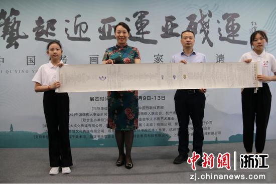 张赢（左二）向浙江省残联捐赠诗词长卷。 活动方供图