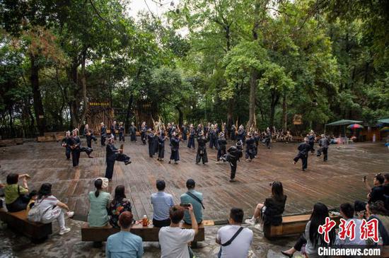 游客在贵州省从江县丙妹镇岜沙苗寨观看民族舞蹈表演。吴德军 摄