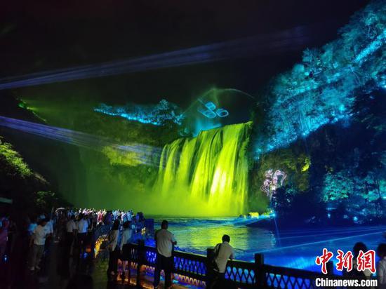 图为夜幕下的黄果树瀑布吸引游客前来游览。周燕玲 摄