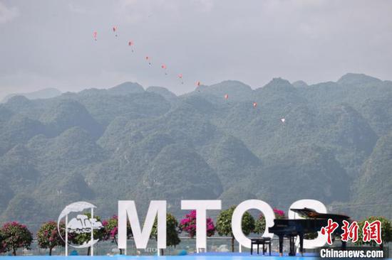 图为2023国际山地旅游暨户外运动大会开幕式现场的滑翔伞表演。中新网记者瞿宏伦摄