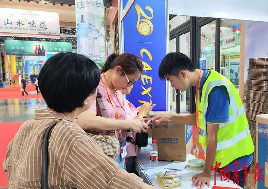 9月16日,广西南宁国际会展中心,两名来自广西柳州市的观众正在邮寄从东博会上采购的商品。当日下午,这个快递服务点已经揽收快递50箱。中青报·中青网见习记者 王军利/摄 9月16日,广西南宁国际会展中心,两名来自广西柳州市的观众正在邮寄从东博会上采购的商品。当日下午,这个快递服务点已经揽收快递50箱。中青报·中青网见习记者 王军利/摄