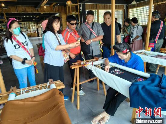 9月17日，来自台湾花莲县光复乡的村民在贵州西江千户苗寨参观苗绣制作。　邱轶轲 摄