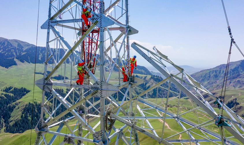 2022年7月3日，施工人员在750千伏伊犁-博州-乌苏-凤凰Ⅱ回输电工程蒙玛拉段山区进行铁塔组立。周广科 摄