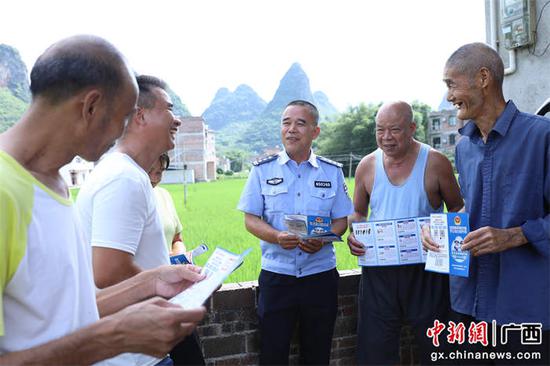 图为民警向村民讲解反诈知识。甘勇 摄 图为民警向村民讲解反诈知识。甘勇 摄