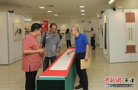 参展作者左起：黄可鑫、顿子斌、阚传好在展览现场观看作品。刘俊苍 摄