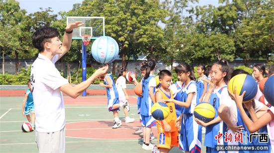 体育达人指导学生进行花式篮球训练。莫岑 摄