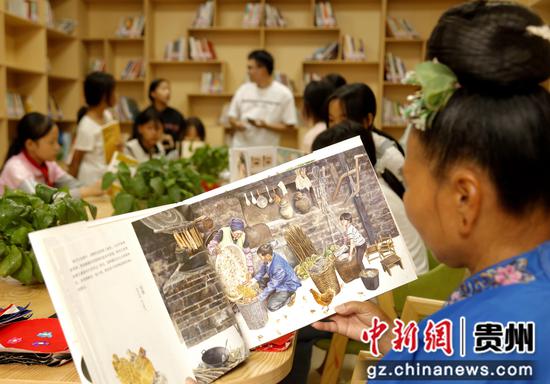 2023年9月27日贵州黔东南州施秉县马号镇六合村农家书屋两位前来准备教学生们刺绣的绣娘也在看相关书籍给自己“充电”。