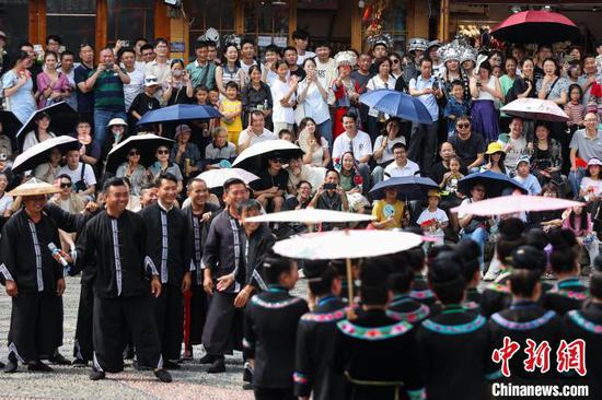 游客在观看西江千户苗寨景区的民俗表演。中新网记者 瞿宏伦 摄