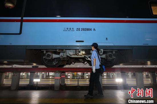 图为机械师在检查“复兴号”动车组列车。中新网记者 瞿宏伦 摄