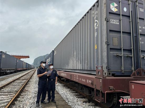 南宁海关所属凭祥海关关员张仕伟、黄长风在铁路口岸对过境货物进行核验关锁。