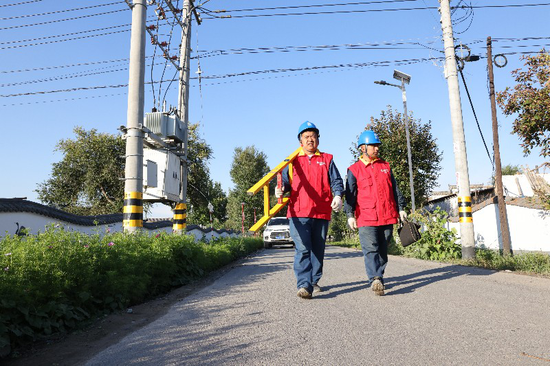 10月6日，国网昌吉供电公司员工走进玛纳斯县小海子村巡检供电线路。沈海涛 摄
