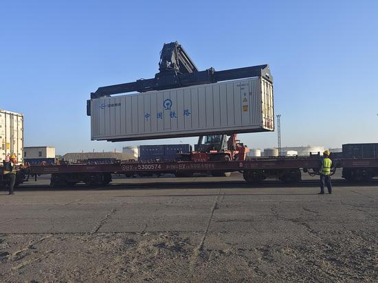 新疆库车铁路货场内正面吊正在吊装首趟香梨冷链专列集装箱。吴发军 摄